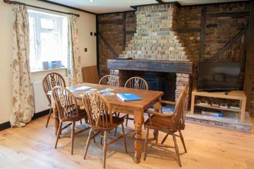 a dining room with a table and chairs and a fireplace at Hurst View Caravan Park in Lymington