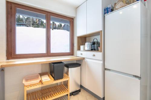 a tiny kitchen with a window in a tiny house at La Perchette - Joli chalet classé 3 étoiles in Chamrousse