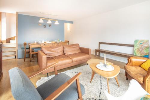 a living room with a couch and a table at La Perchette - Joli chalet classé 3 étoiles in Chamrousse