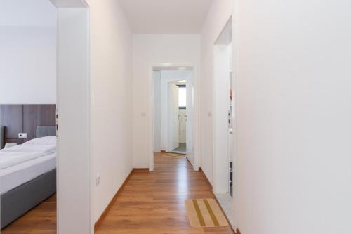 a bedroom with white walls and a bed and a wooden floor at pazaric residence in Doljani