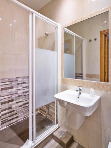 a white bathroom with a sink and a shower at Hostal Bianco in Madrid