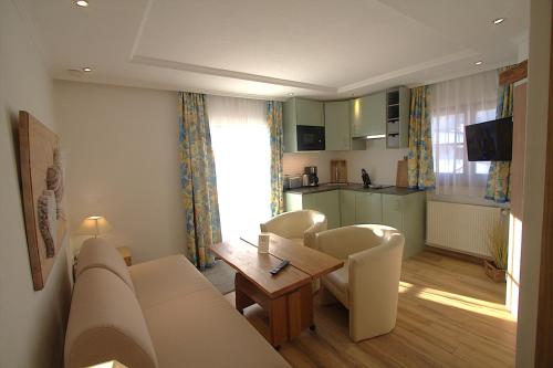 a living room with a couch and a table and a kitchen at Haus Sonnenschein in Grainau