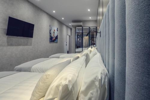 a room with four beds with white pillows at Hotel Dirista in Shkodër