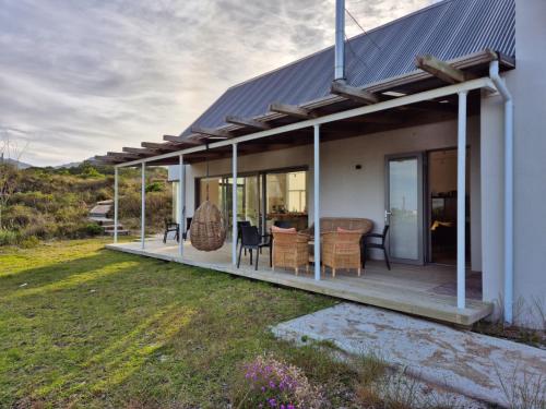 a house with a large deck with glass doors at The Dunes Pringle Bay in Pringle Bay