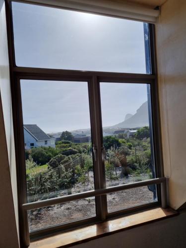 a window with a view of the desert outside at The Dunes Pringle Bay in Pringle Bay