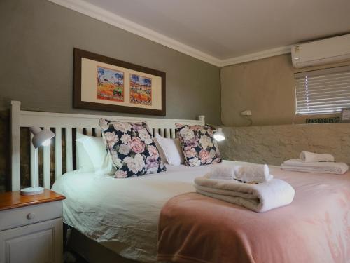 a bedroom with a bed with towels on it at Barn Guesthouse in Kroonstad