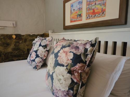 a bed with two pillows on top of it at Barn Guesthouse in Kroonstad