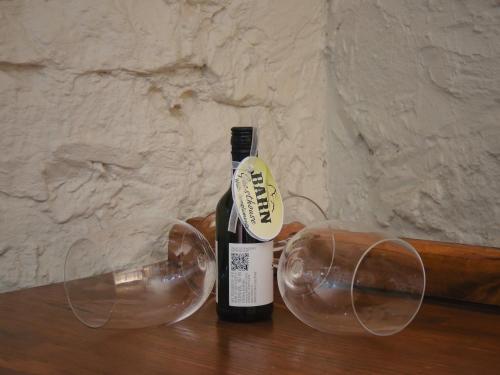 a bottle of wine and two wine glasses on a table at Barn Guesthouse in Kroonstad