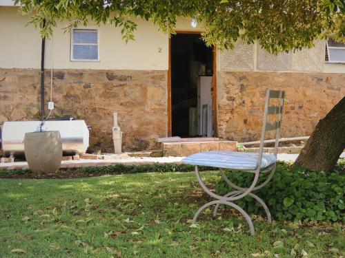 a bench sitting in the grass in front of a house at Barn Guesthouse in Kroonstad