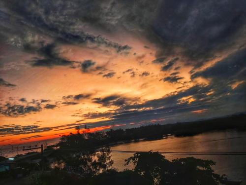 a sunset over a body of water with the sky at Suítes Luxo Marambaia- Epic House in Rio de Janeiro