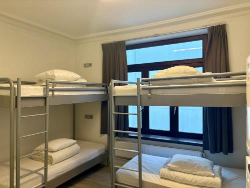 two bunk beds in a room with a window at The Legacy by 2GO4 City Center in Brussels