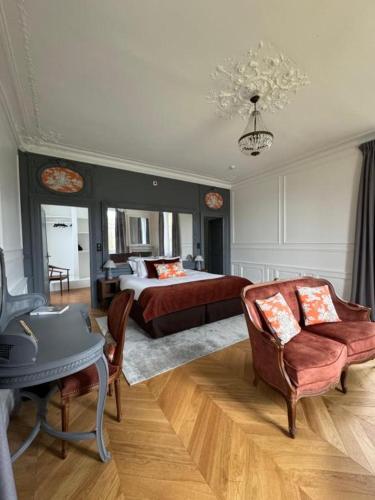a bedroom with a bed and a table and chairs at Château De La Bûcherie in Saint-Cyr-en-Arthies