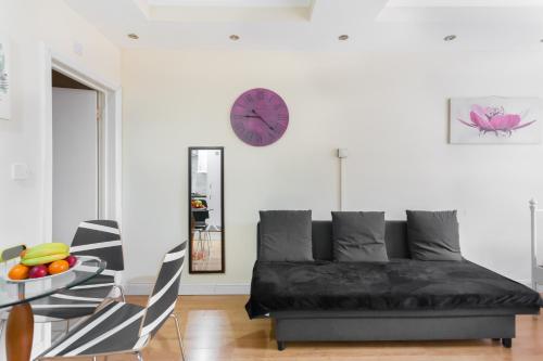 ロンドンにあるEuston Budget Apartments and Roomsのリビングルーム(ソファ、壁掛け時計付)