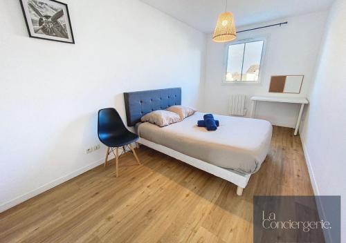 Un dormitorio con una cama y una silla dentro. en La Maison Foucault -Jardin Poitiers Chu Futuroscope, en Poitiers