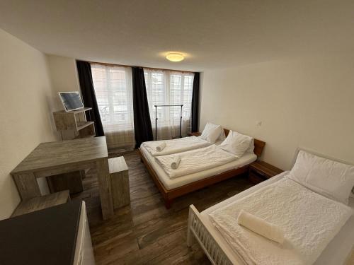 a room with two beds and a table and a window at Family Home - 30 in Wilderswil