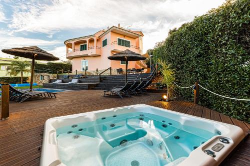 a jacuzzi tub on a deck with a house at Villa Arade Riverside - Jacuzzi and Heated Pool by AlgarStays in Silves