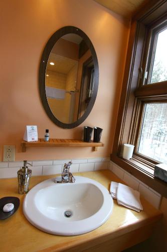 a bathroom with a sink and a mirror on a counter at Escale du Nord in Mont-Tremblant