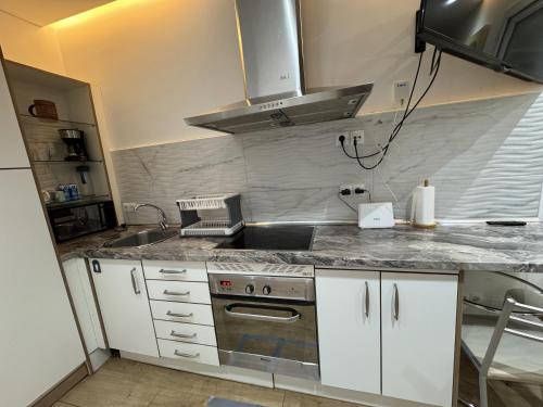 a kitchen with a sink and a stove top oven at Apartamento con patio en Madrid centro in Madrid
