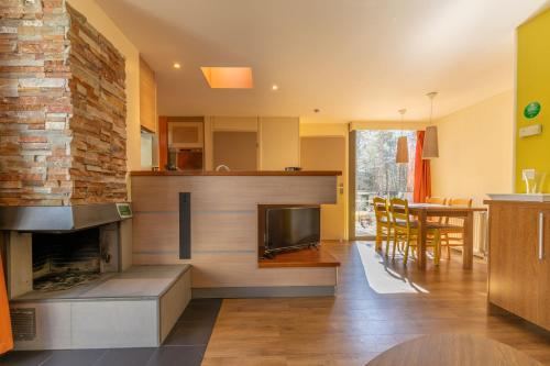 un salon avec cheminée et une salle à manger dans l'établissement Cottage 8p-les Hauts de Bruyères-220, à Chaumont-sur-Tharonne