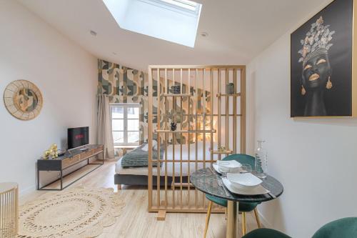 a bedroom with a bed and a table in a room at La Savane, Studio Calme & Hyper Centre Villefranche-sur-Saône in Villefranche-sur-Saône