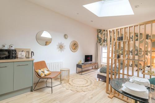 a living room with a kitchen and a dining room at La Savane, Studio Calme & Hyper Centre Villefranche-sur-Saône in Villefranche-sur-Saône
