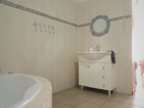 a white bathroom with a tub and a sink at Barn Guesthouse in Kroonstad