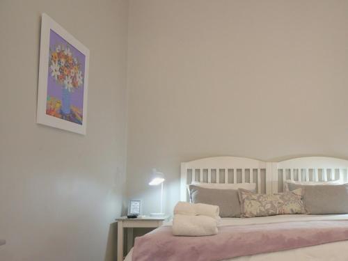 a bedroom with a bed with a picture on the wall at Barn Guesthouse in Kroonstad