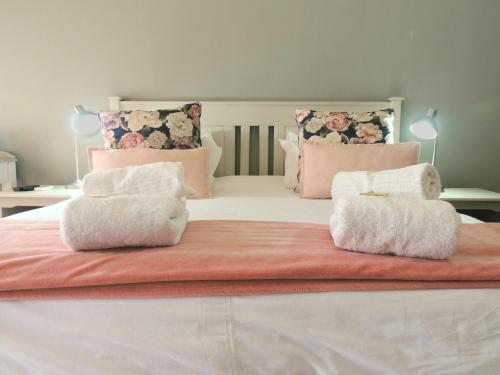 a large bed with two white towels on it at Barn Guesthouse in Kroonstad