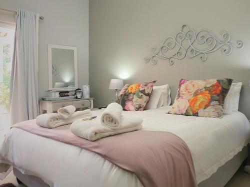 a bedroom with a bed with towels on it at Barn Guesthouse in Kroonstad