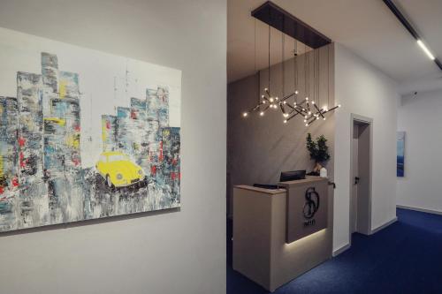 a hallway with a painting of a yellow car on the wall at Hotel Dirista in Shkodër