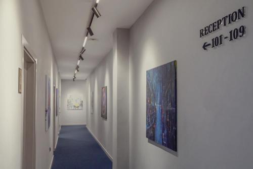a hallway with paintings on the walls of a room at Hotel Dirista in Shkodër