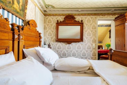 ein Schlafzimmer mit einem großen Bett mit einem hölzernen Kopfteil in der Unterkunft Villa Charlotte in Bad Harzburg