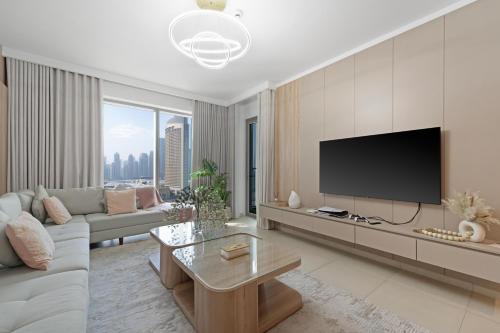 a living room with a couch and a tv at Amazing 2BR Home Burj Khalifa View Steps Walk to DubaiMall in Dubai