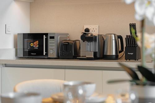 a counter top with a coffee maker and a microwave at Amazing 2BR Home Burj Khalifa View Steps Walk to DubaiMall in Dubai