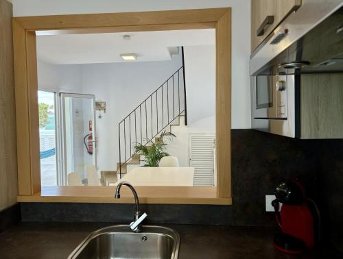 a kitchen with a large window over a sink at Villa Son Saura in Cala en Forcat