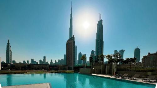a swimming pool with a view of a city at Amazing 2BR Home Burj Khalifa View Steps Walk to DubaiMall in Dubai
