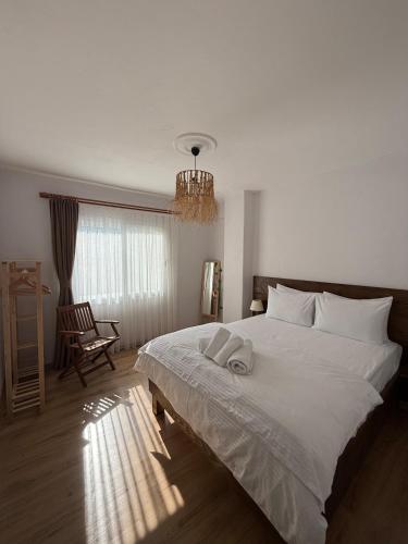 a bedroom with a large bed with two towels on it at Urla The Orange House in Kuscular