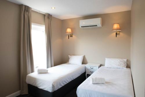 dos camas sentadas una al lado de la otra en una habitación en Lily Sands Inn, en Melbourne
