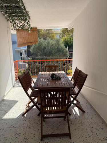 a wooden table and chairs on a patio at Urla The Orange House in Kuscular