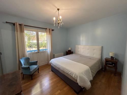 - une chambre avec un lit, une chaise et un lustre dans l'établissement Maison charmante 6 personnes, à Arcachon