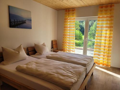 two twin beds in a room with a window at Ferienwohnungen Meyer in Heilsbronn