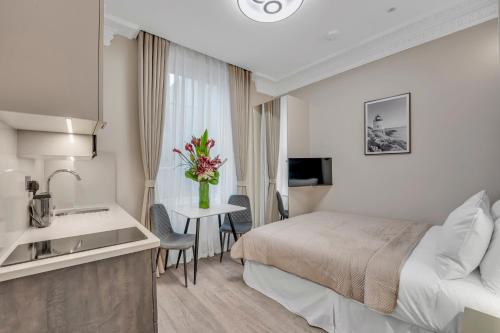 a hotel room with a bed and a table with flowers at Cleveland Residences Bloomsbury in London