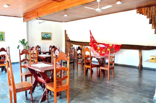 Canoas Hotel في بوكونيه: غرفة طعام مع طاولات وكراسي خشبية