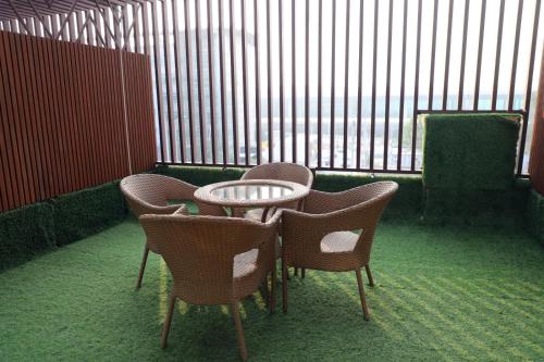 a table and chairs in a room with windows at Airport Hotel in New Delhi
