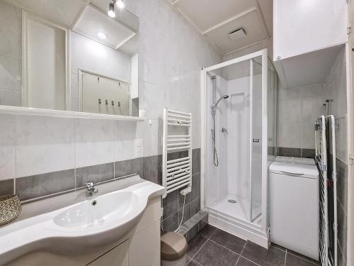 une salle de bain blanche avec un lavabo et une douche dans l'établissement Budget studio proche lac, à Sévrier