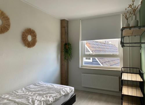 a bedroom with a bed and a window at Spacious house next to the mill! in Westkapelle