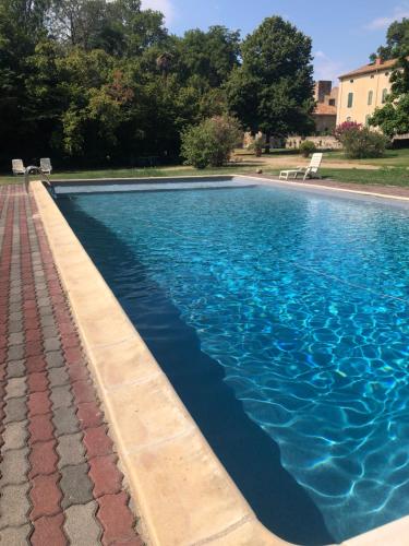 a swimming pool with blue water in a yard at Terrasse avec vue Domaine Viticole in Sallèles-dʼAude