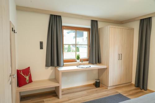 a bedroom with a window with curtains and a desk at Ferienhaus Anna in Zell am Ziller