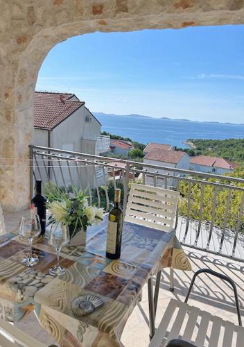 a table with two bottles of wine on a balcony at Murter Inn in Murter