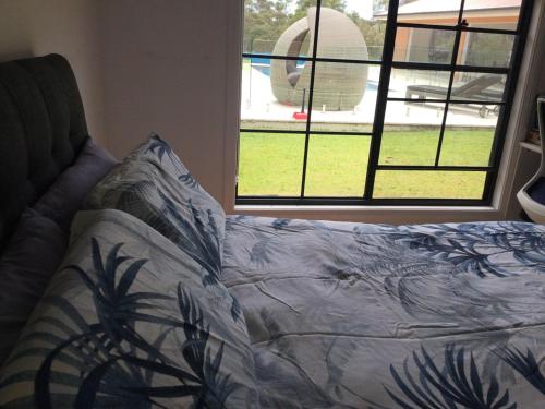 a bed sitting in a room with a window at Great friends and family getaway in Annangrove